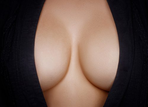 Photo focusing on a woman's cleavage in a black dress