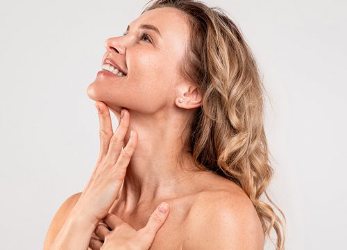 Photo of a middle-aged woman touching her neckline